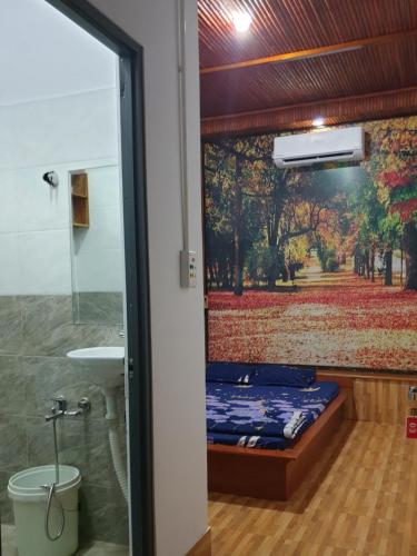 Chi LăngにあるBoss cà phê & Homestayのベッド1台、壁に絵画が描かれたバスルームが備わります。