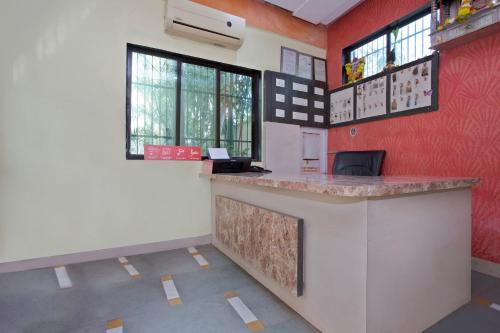 a bar in a room with red walls and windows at Hotel O Capital O Sai Icon Residency in Titwala