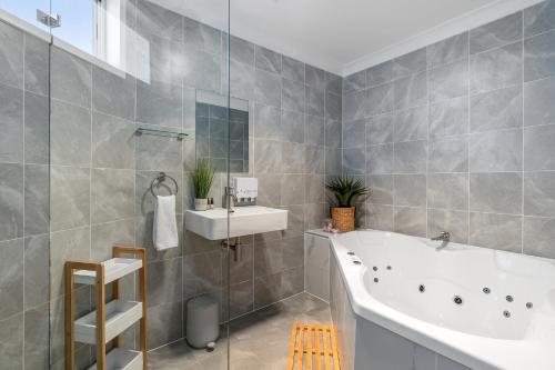 a bathroom with a tub and a sink at Mollymook Motel in Mollymook