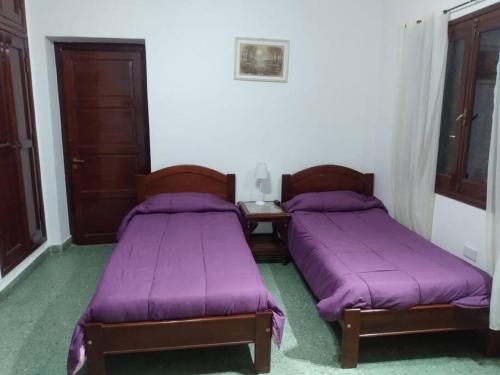 2 camas en una habitación con sábanas moradas en Guicarodia II en Salta