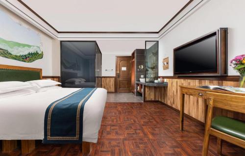 a hotel room with a bed and a flat screen tv at Nost algia Hotel Near University of Technology -Shanxi museum 时光漫步酒店 太原理工大学下元店 Free fresh ground coffee,Free laundry service in Taiyuan