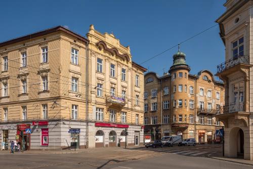 a row of tall buildings on a street with cars at 70s Guest room in Kraków