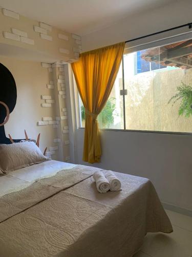 una camera con un letto e una grande finestra di Aconchego de Itapuã a Salvador