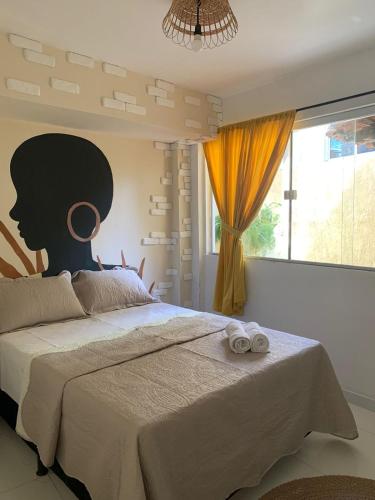 um quarto com uma cama grande e uma janela grande em Aconchego de Itapuã em Salvador