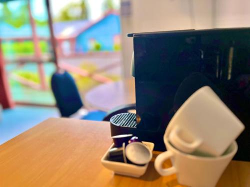 a desk with a coffee cup and a computer monitor at Adventure Lodge and Motels and Tongariro Crossing Track Transport in National Park