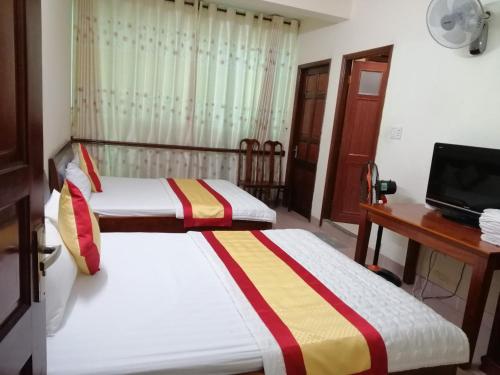 a bedroom with two beds and a television in it at Motel Toàn Thắng 2 in Vung Tau