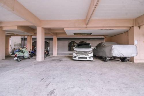 a parking lot with a car and a truck and motorcycles at We Residence Studio in Pattaya Central