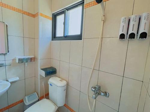 a small bathroom with a toilet and a sink at Dear B&B Building II in Jincheng