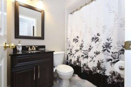 uma casa de banho com uma cortina de chuveiro em preto e branco e um WC. em Modern & Spacious 2 Bedrooms+2 Bathrooms Bungalow in Oakville em Oakville