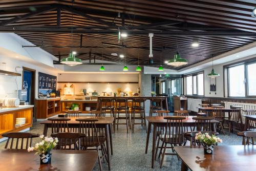 a restaurant with tables and chairs and a kitchen at Nost algia Hotel Near University of Technology -Shanxi museum 时光漫步酒店 太原理工大学下元店 Free fresh ground coffee,Free laundry service in Taiyuan
