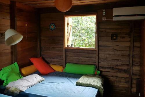 ein Bett in einem Zimmer mit Fenster in der Unterkunft La Casa de Colores in Garuhapé