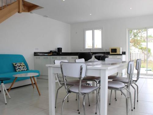 - une cuisine avec une table et des chaises blanches dans l'établissement Maison au cœur de Saint-Denis-d'Oléron, 6 couchages, jardin clos, proche plage et port - FR-1-246A-53, à Saint-Denis-dʼOléron