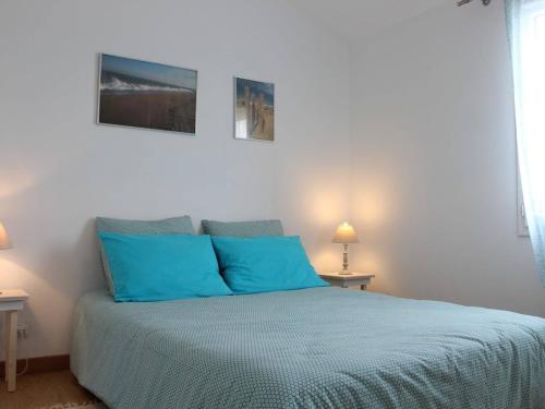 - un lit blanc avec des oreillers bleus dans l'établissement Maison au cœur de Saint-Denis-d'Oléron, 6 couchages, jardin clos, proche plage et port - FR-1-246A-53, à Saint-Denis-dʼOléron