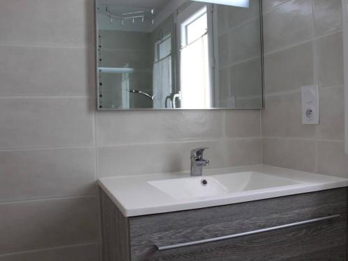 une salle de bain avec un lavabo blanc et un miroir dans l'établissement Maison au cœur de Saint-Denis-d'Oléron, 6 couchages, jardin clos, proche plage et port - FR-1-246A-53, à Saint-Denis-dʼOléron