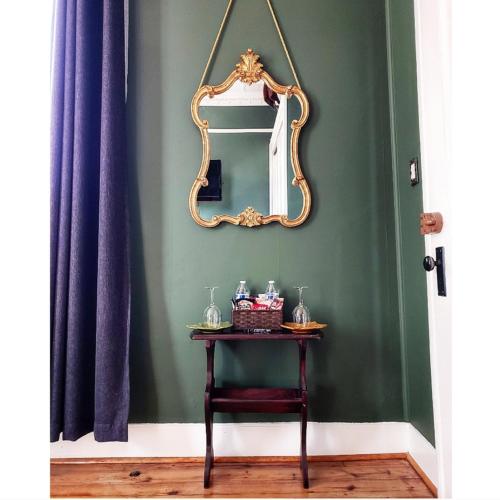 a table with a mirror on a green wall at South Court Inn in Luray
