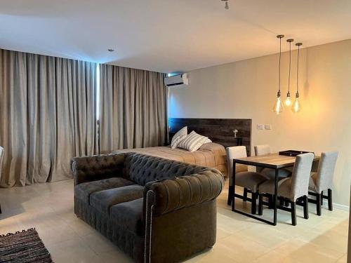 1 dormitorio con sofá, cama y mesa en Elegante Estudio Nordelta Bay , Piscina, Parking en Tigre