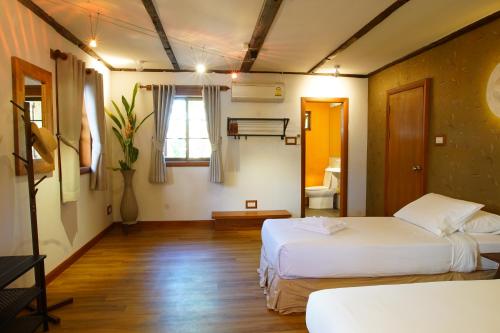 een hotelkamer met 2 bedden en een raam bij Rimsuan Garden Home in Chiang Mai