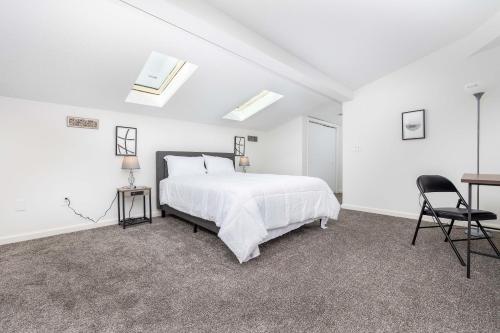 a white bedroom with a bed and a desk at Exquisite Downtown Loft Apartment in Hartford