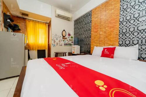 a bedroom with a bed with a red blanket on it at RedLiving Apartemen Green Lake View Ciputat - Pelangi Rooms 3 Tower E in Tangerang