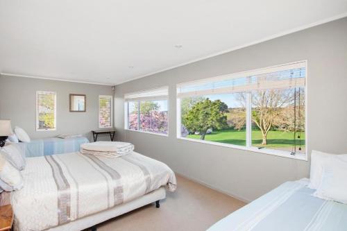 a bedroom with two beds and a large window at Maxwell's Golf Retreat in Bombay