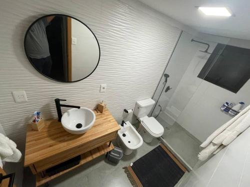 a bathroom with a sink and a mirror and a toilet at Diseño confort, tina a pasos de la cañada in Villa Serrana