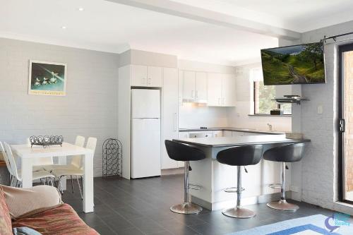 a kitchen with a counter and a table with chairs at Apollo Unit 15 1st Floor in Narooma