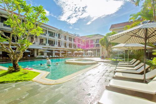 uma piscina num resort com pessoas em HOI AN HISTORIC HOTEL em Hoi An