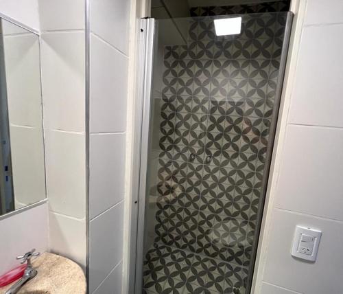 una ducha con una puerta de cristal junto a un lavabo en Monoambiente céntrico en Mendoza en Mendoza