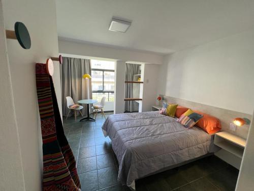 1 dormitorio con 1 cama y 1 dormitorio con mesa en Monoambiente céntrico en Mendoza en Mendoza