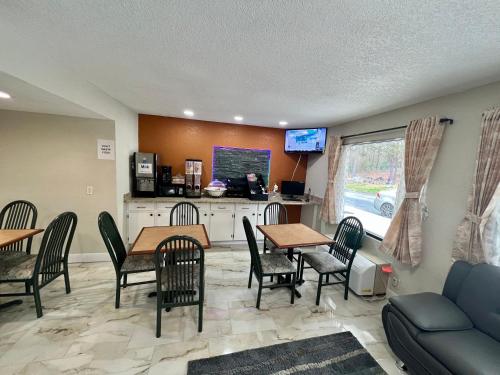 a living room with tables and chairs and a couch at Key West Inn - Roanoke in Roanoke