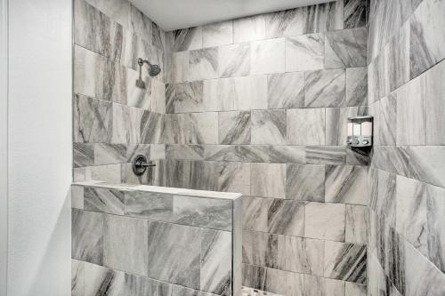 y baño con ducha y azulejos de mármol. en Lakefront Frankston Home with Guest Studio!, en Coffee City