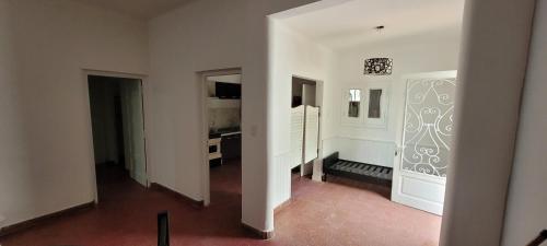 Habitación con pasillo con paredes blancas y cocina. en RAMALLO CASA CENTRICA en Ramallo