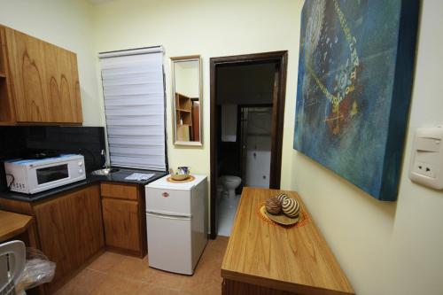 a small kitchen with a white refrigerator and a table at OKE Apart Hotel in San Lorenzo