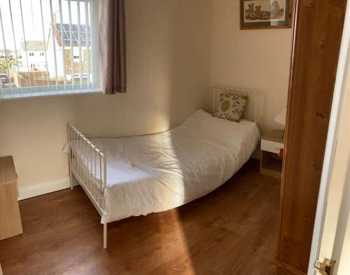 a small bedroom with a crib with a window at Challoner House - sleeps 5 in Hartlepool