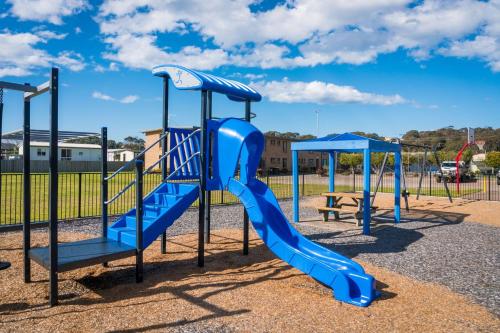 a playground with a blue slide in a park at Apollo Unit 25 Ground Floor in Narooma