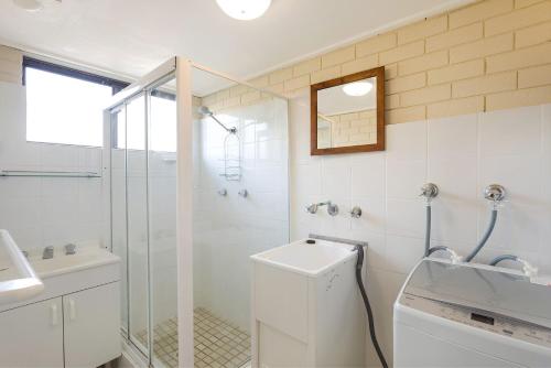 een badkamer met een douche, een toilet en een wastafel bij Apollo Unit 26 Ground Floor in Narooma