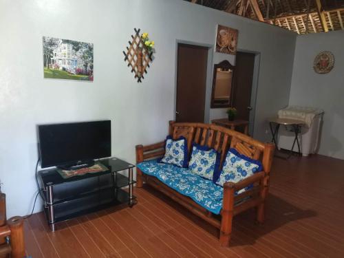 a living room with a couch and a flat screen tv at Zeah's Beach Place in Bulusan