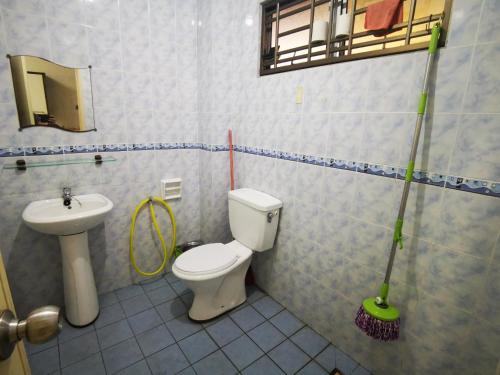 a bathroom with a toilet and a sink and mop at Ames Leng I-City Home Sweet Home in Shah Alam
