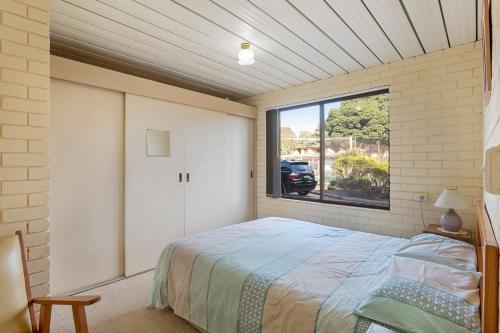 a bedroom with a bed and a large window at Apollo Unit 27 - Ground Floor - C Block in Narooma