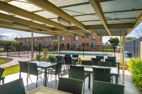 a patio with tables and chairs and a pool at Apollo Unit 27 - Ground Floor - C Block in Narooma