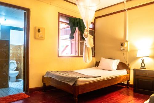 sypialnia z łóżkiem i oknem w obiekcie Xaymountry Don Khon City Center Residence and Guesthouse w mieście Ban Donsôm