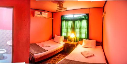 a small room with two beds and a window at Xaymountry Don Khon City Center Residence and Guesthouse in Ban Donsôm