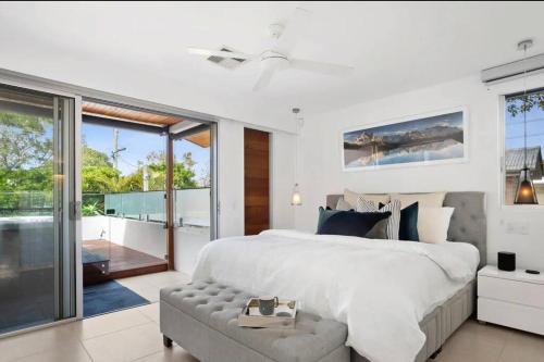 ein Schlafzimmer mit einem großen weißen Bett und einem Balkon in der Unterkunft Sunshine Beach Gem in Sunshine Beach