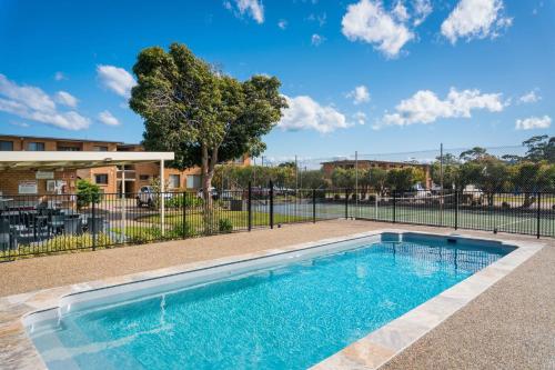 a swimming pool in front of a fence at Apollo Unit 28 Ground Floor in Narooma
