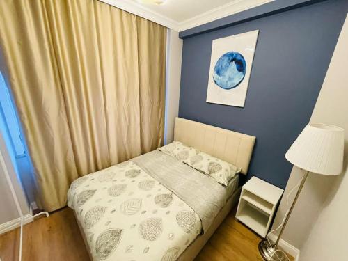 a small bedroom with a bed and a blue wall at Private Apt, 2 mins to Transp. in Istanbul