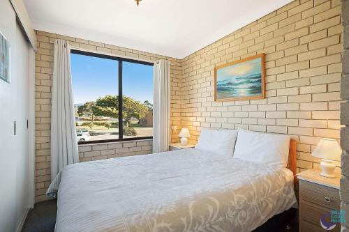 a bedroom with a bed and a large window at Apollo Unit 30 First Floor in Narooma