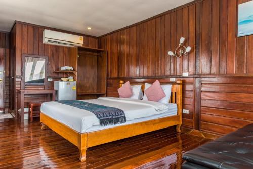 um quarto com uma cama com paredes com painéis de madeira em Riverside Chiangkhan em Ban Mai Ta Saeng