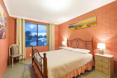 a bedroom with a large bed and a window at Apollo Unit 7 1st Floor in Narooma