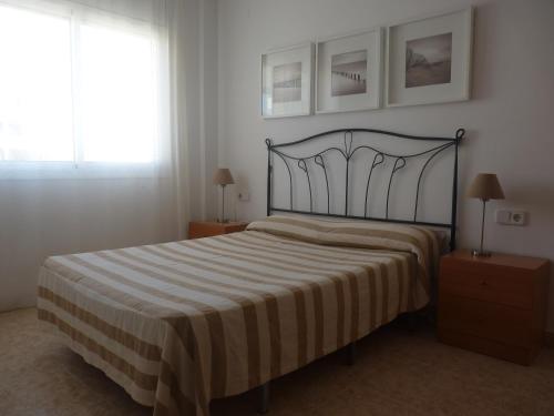 - une chambre avec un lit avec une couverture rayée et une fenêtre dans l'établissement JOYAPARTMENTS La Joya, à Miami Platja