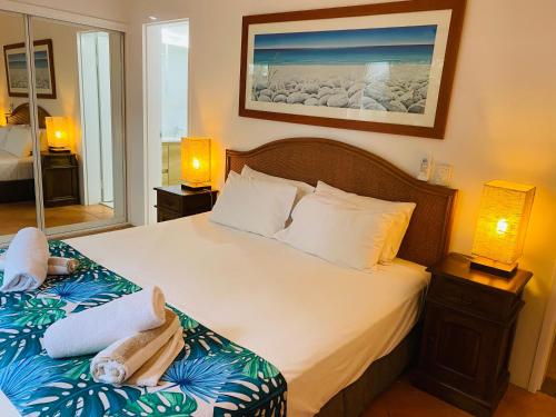 a bedroom with two beds with towels on them at BeachView Apartments at Villa Paradiso in Palm Cove